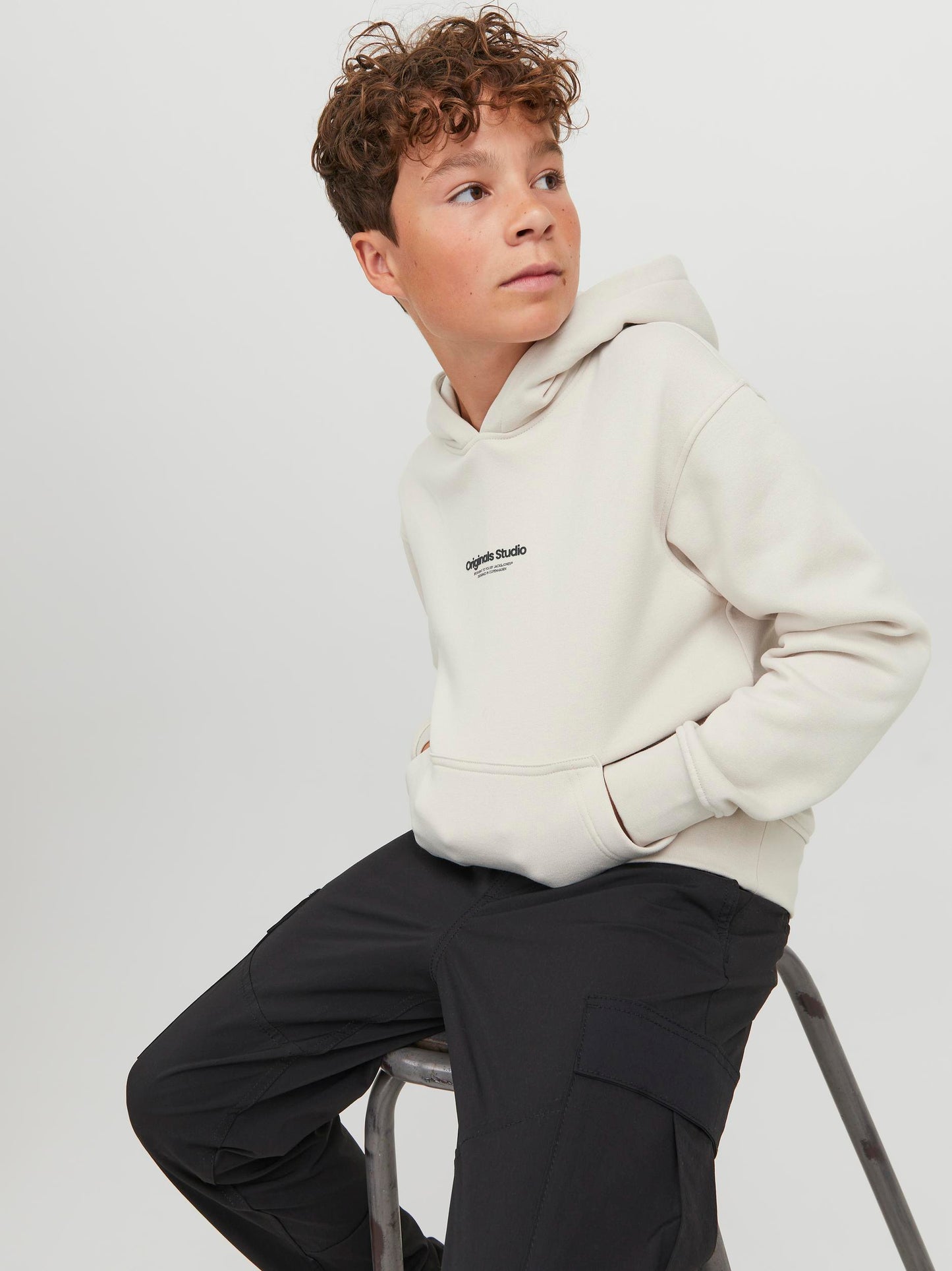 Vit, naturvit hoodie från Jack & Jones till ungdom kille, pojke. Luvtröja i enfärgat vitt med logga på bröstet i deras omtyckta modell Vesterbro. FIcka på magen.