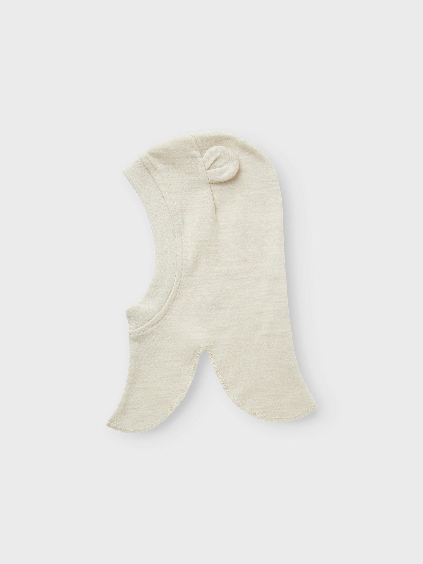 Söt beige balaclava till din baby pojke eller flicka. Mysig mössa som sitter bra på din bebis huvud och du vet att det inte blir kallt i nacke, hals och att endast babyns lilla ansikte sticker fram ur den varma mössan. Ull är ett naturmaterial känt för sina termiska egenskaper, mjukhet och fluffiga utseende. I kallt väder håller ull värmen och under varma dagar absorberar den svett, vilket gör den till ett bra val oavsett årstid.