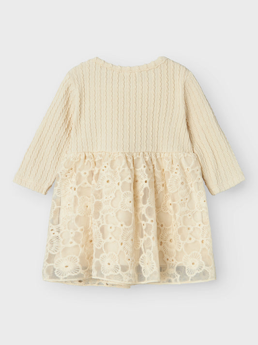 Söt baby klänning med kjol av vacker spets. Ekologisk bebis klänning som passar perfekt för julens alla tillfällen och andra speciella tillfällen som din baby flicka ska vara med om första året. Jersey är ett lätt och stretchigt tyg med en mjuk yta och insida för en bekväm känsla och rörelsefrihet. Name it, NBFSILINE