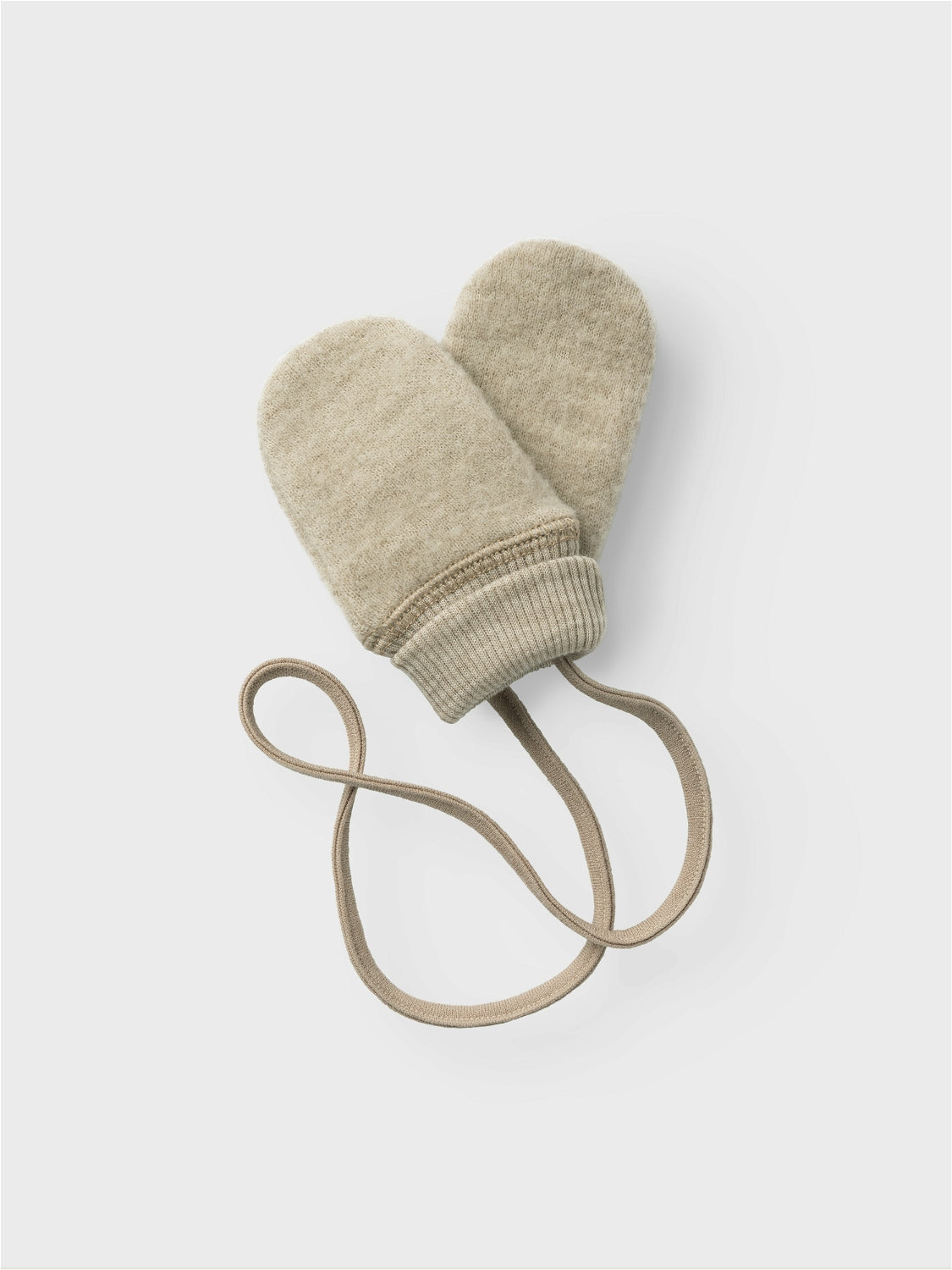 Mysiga bebis vantar i beige till din lilla flicka eller pojke. Mjukaste merinoull som värmer små händer är det bästa som finns. Sitter ihop med ett långt band som du har innanför overallen eller jackan så om din baby skulle lyckas dra av sig en vante hänger den praktiskt kvar och kan inte försvinna.
Sätt pricken över i:et till ditt barns outfit med festliga, coola och praktiska accessoarer perfekta för både vardagsbruk och speciella tillfällen. Ull är ett naturmaterial känt för sina termiska egenskap