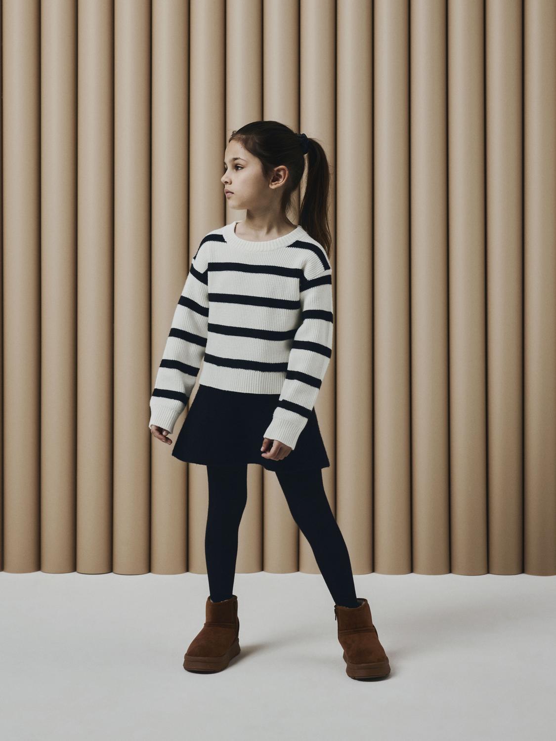 Flicka klädd i stickad tröja och stickad kjol. Svart stickad kjol med mycket vidd. Kjol till flicka / tjej. Supermysig och mjuk.
Sätt ihop den perfekta outfiten för ditt barn med kvalitativa vardagsstilar och skapa en bekväm och trendig look. Ribbstickad har ett vertikalt, randigt mönster och bra elasticitet för en skön känsla och en tidlös look.
Produkttyp: Skater kjol
Längd/Storlek: Kort