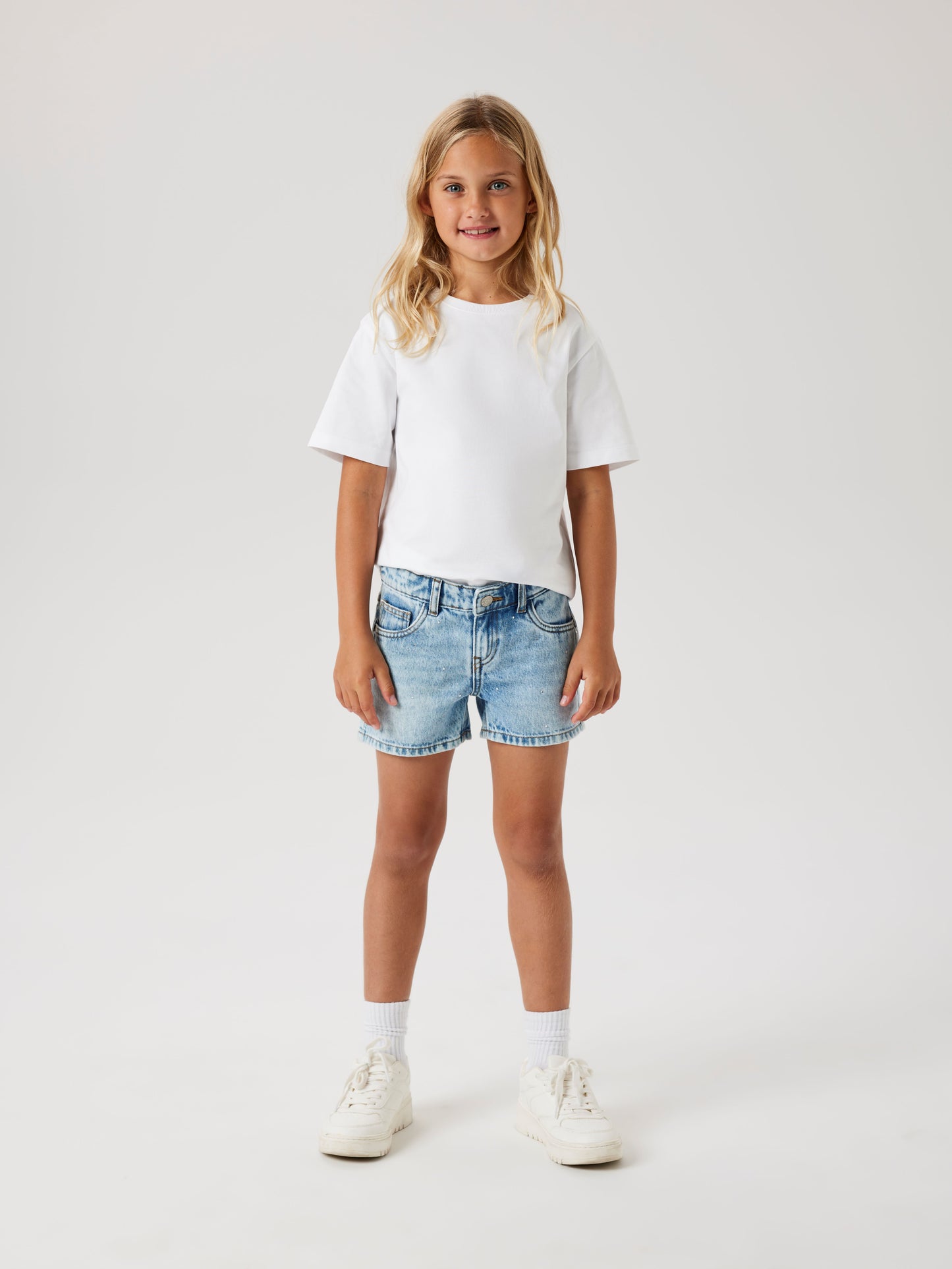 Tjej klädd i blå jeans shorts med strass stenar för glitter och glamour till flicka. Sköna jeansshorts med pärlor från Name it.
NKFROSE REG DNM SHORTS 6042-AC NOOS
13239976