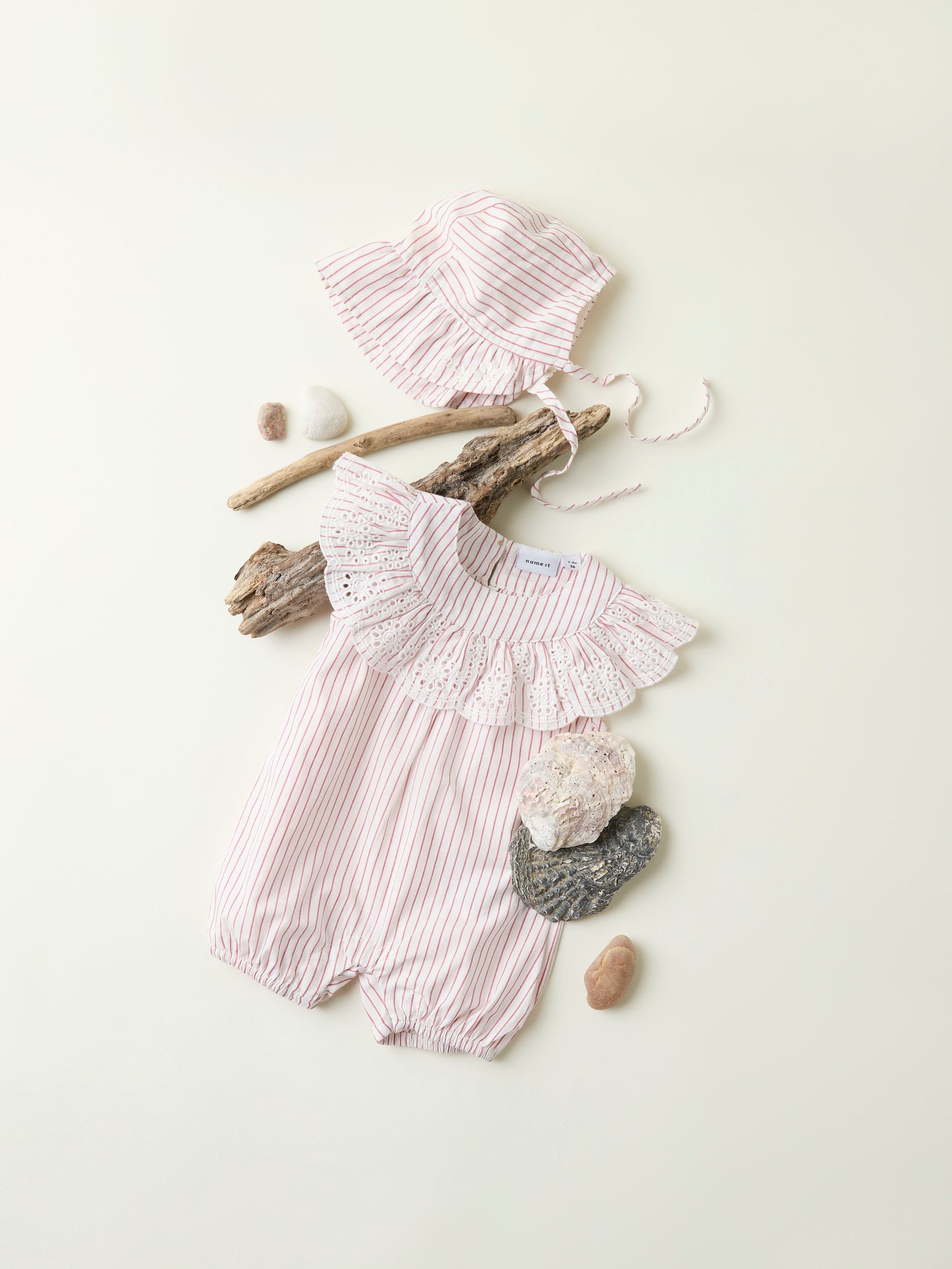 Randig vit och röd sunsuit till bebis flicka. Baby sparkdräkt, soldräkt med shorts i söt ekologisk modell med spets och volanger. Klassisk modell av jumpsuit från Name it.
NBFFILINE SUNSUIT
13240486