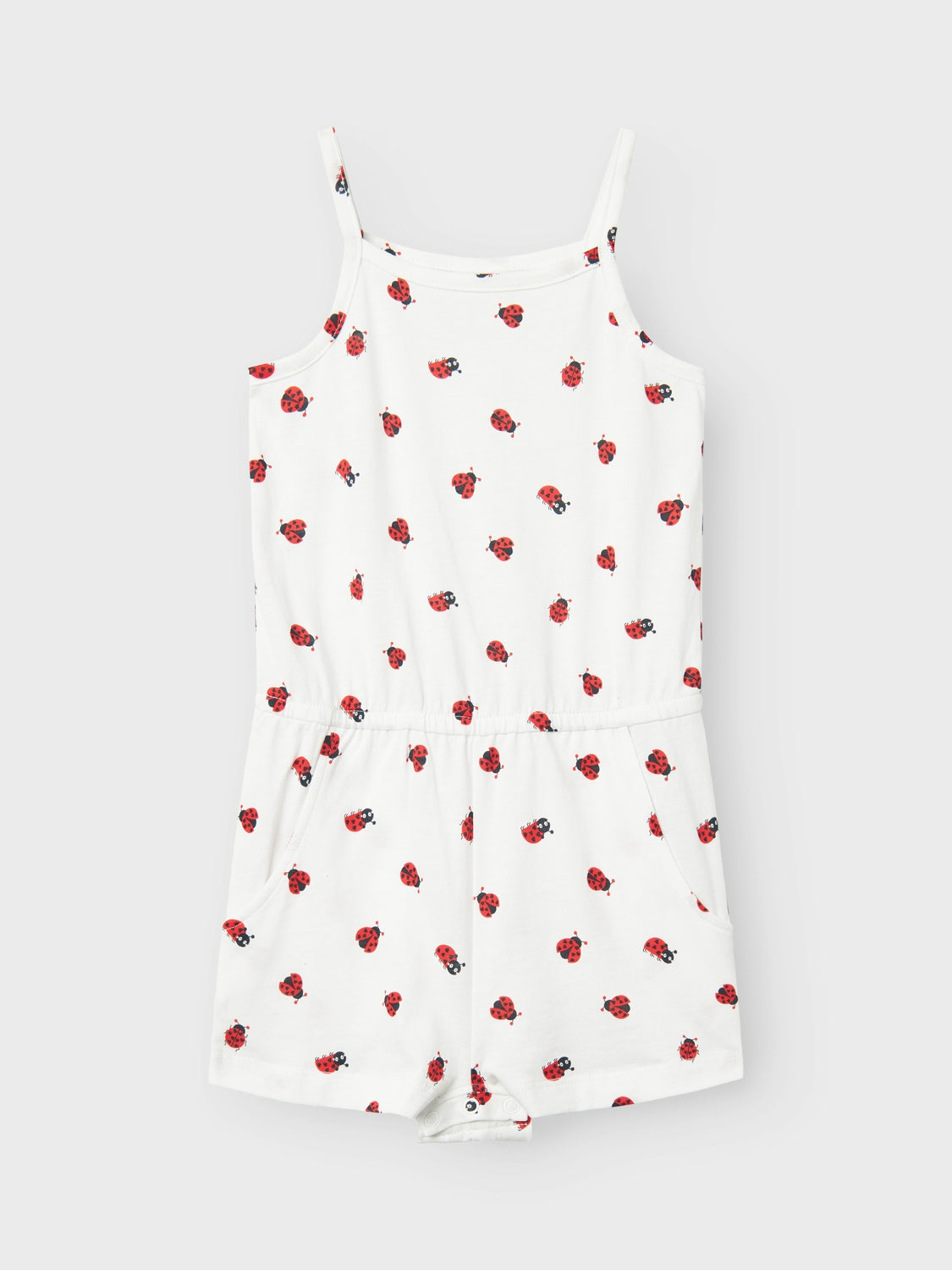 Vit jumpsuit med röda små söta nyckelpigor. Shortsdress med smala axelband perfekt för lek och skoj.