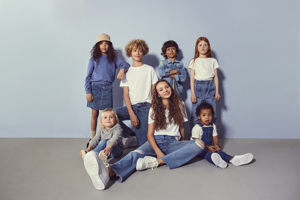 Ett gäng barn med olika denimkläder på sig posar för en bild.