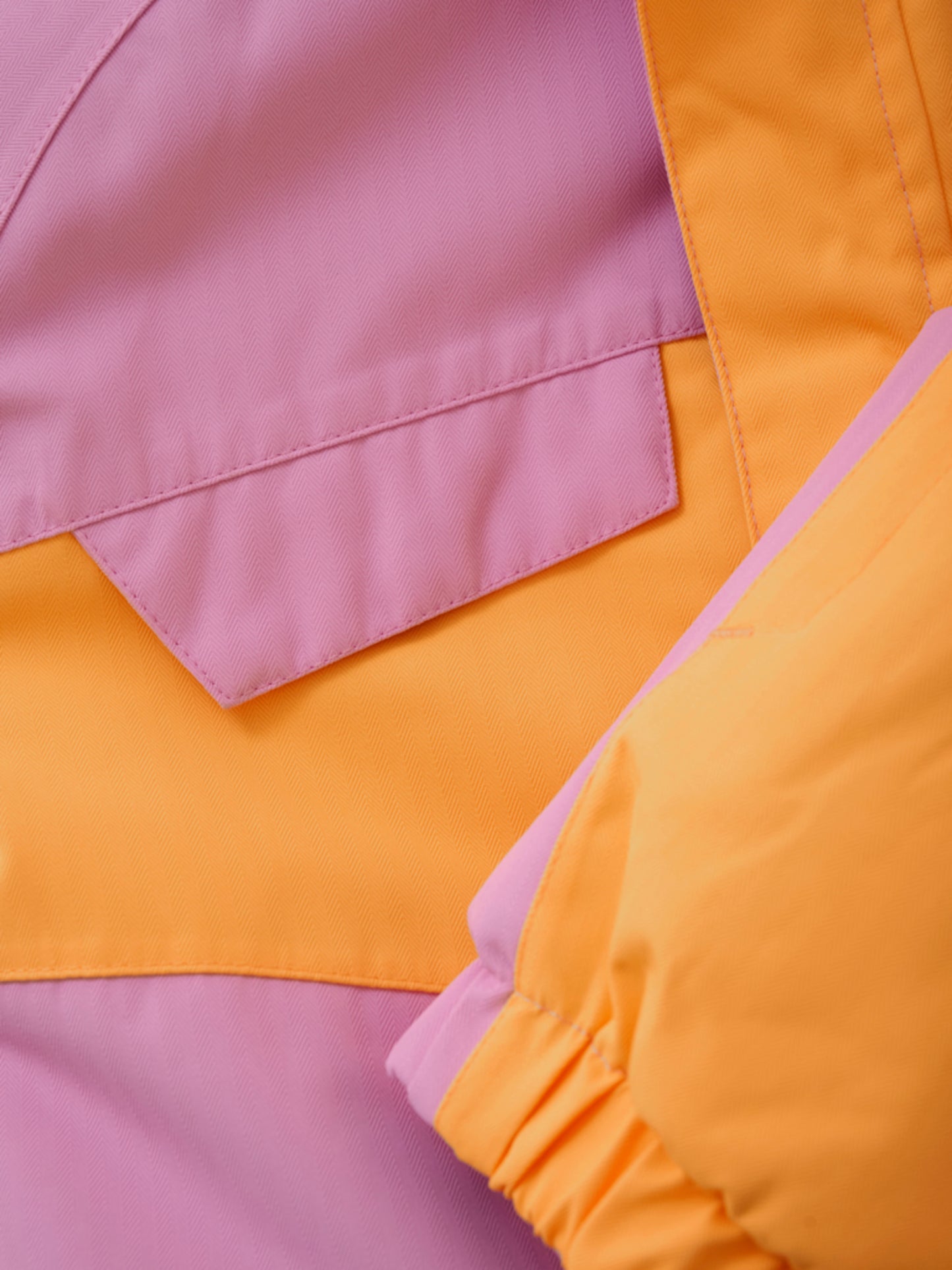 Cool färgblocks overall för ditt barn i slitstarkt material i rosa och orange. Vinteroverall till flicka, tjej. Materialet är andningsbart, vindtätt och vattentätt, så ditt barn kan vistas ute i regn, snö och blåst utan att bli kall och blöt.

Testad slitstyrka på 60 000 gnidningar, vattenpelartryck på 10 000 mm. och andningsförmåga på 8 000 g.
Overallen stängs med en kvalitetsdragkedja framtill.
Hakskydd ser till att dragkedjan känns mjuk under hakan.
Reflexdetaljer på baksidan.
Den har en namnskylt inuti.