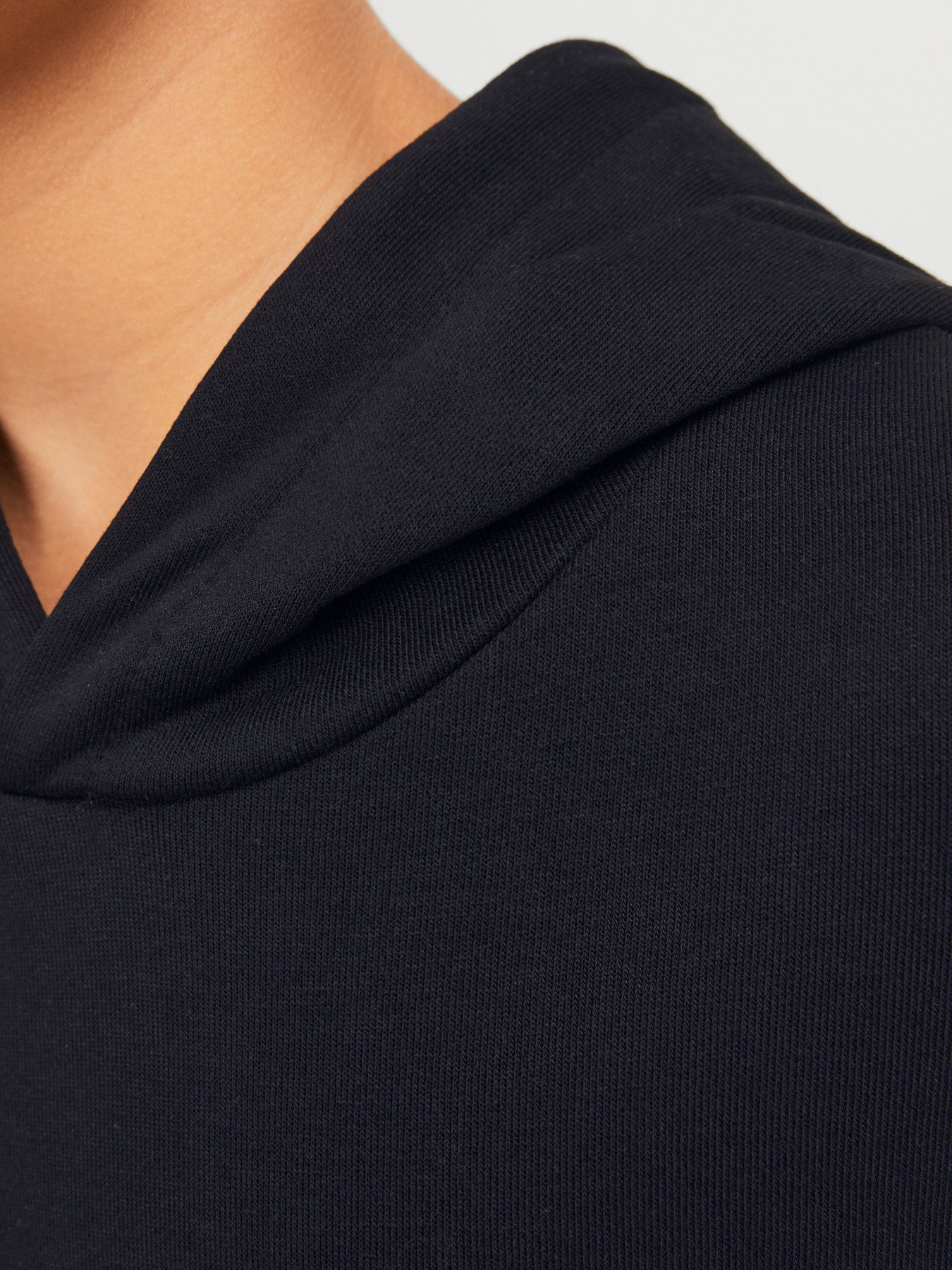 Jack & Jones Junior svart hoodie för pojke med fast huva, känguruficka och mjuk sweatkvalitet