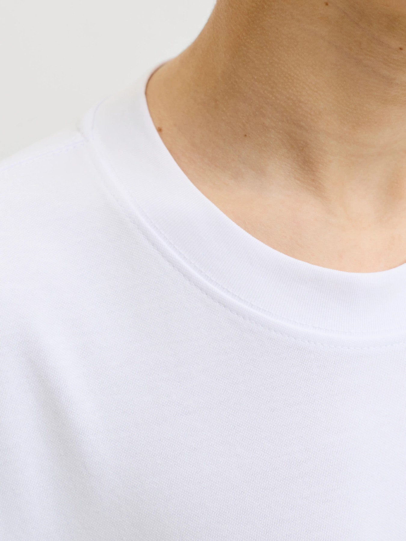 Jack & Jones Junior vit loose fit t-shirt för pojke i ekologisk bomull och återvunnen polyester med rund halsringning och mjuk interlock-kvalitet