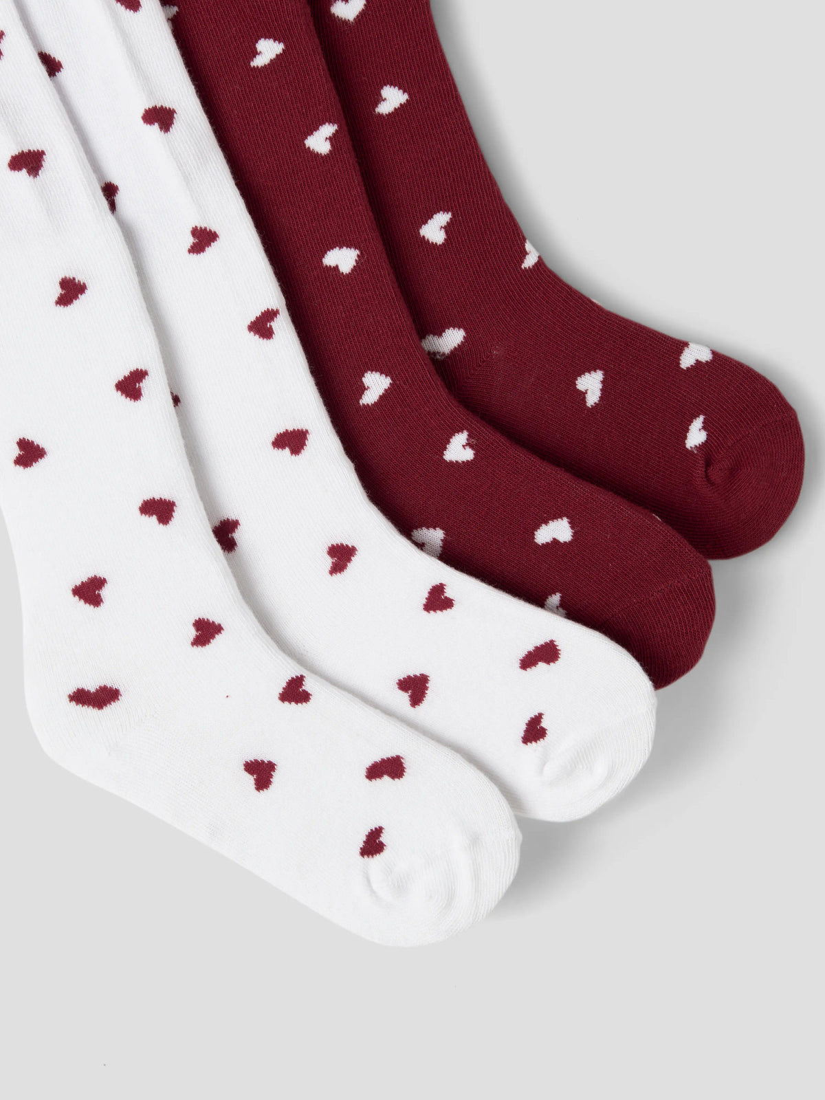 Name It Vichristmas julstrumpbyxor 2-pack för flicka i vitt och vinrött med hjärtmönster.