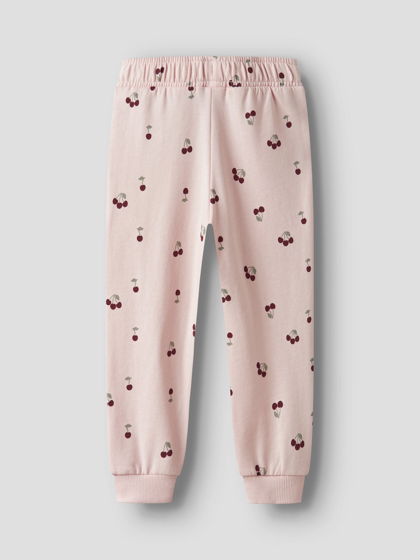 Name It ljusrosa mjukisbyxor med röda körsbär för flicka i ekologisk bomull med elastisk midja och mjuk sweatkvalitet