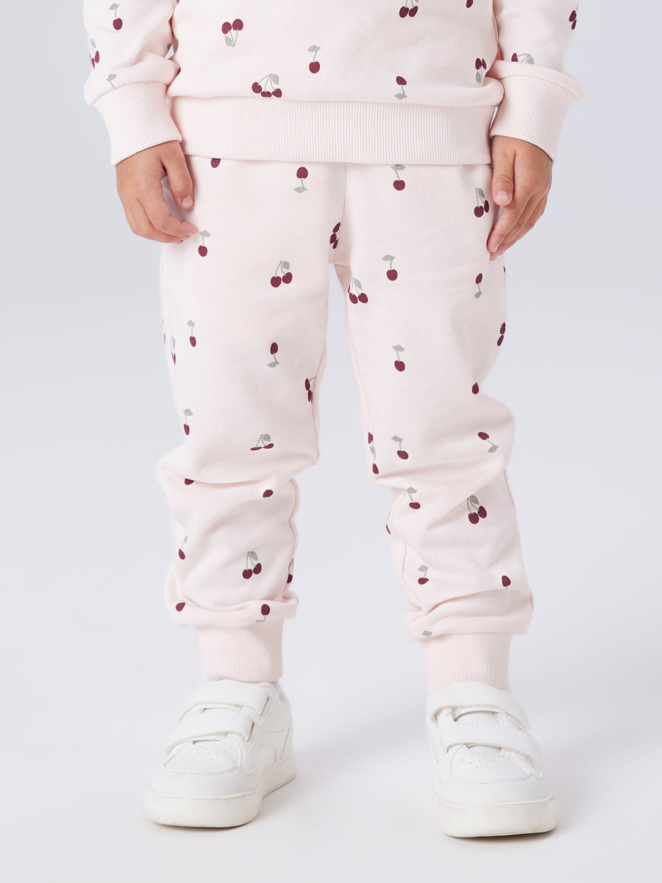 Name It ljusrosa mjukisbyxor med röda körsbär för flicka i ekologisk bomull med elastisk midja och mjuk sweatkvalitet