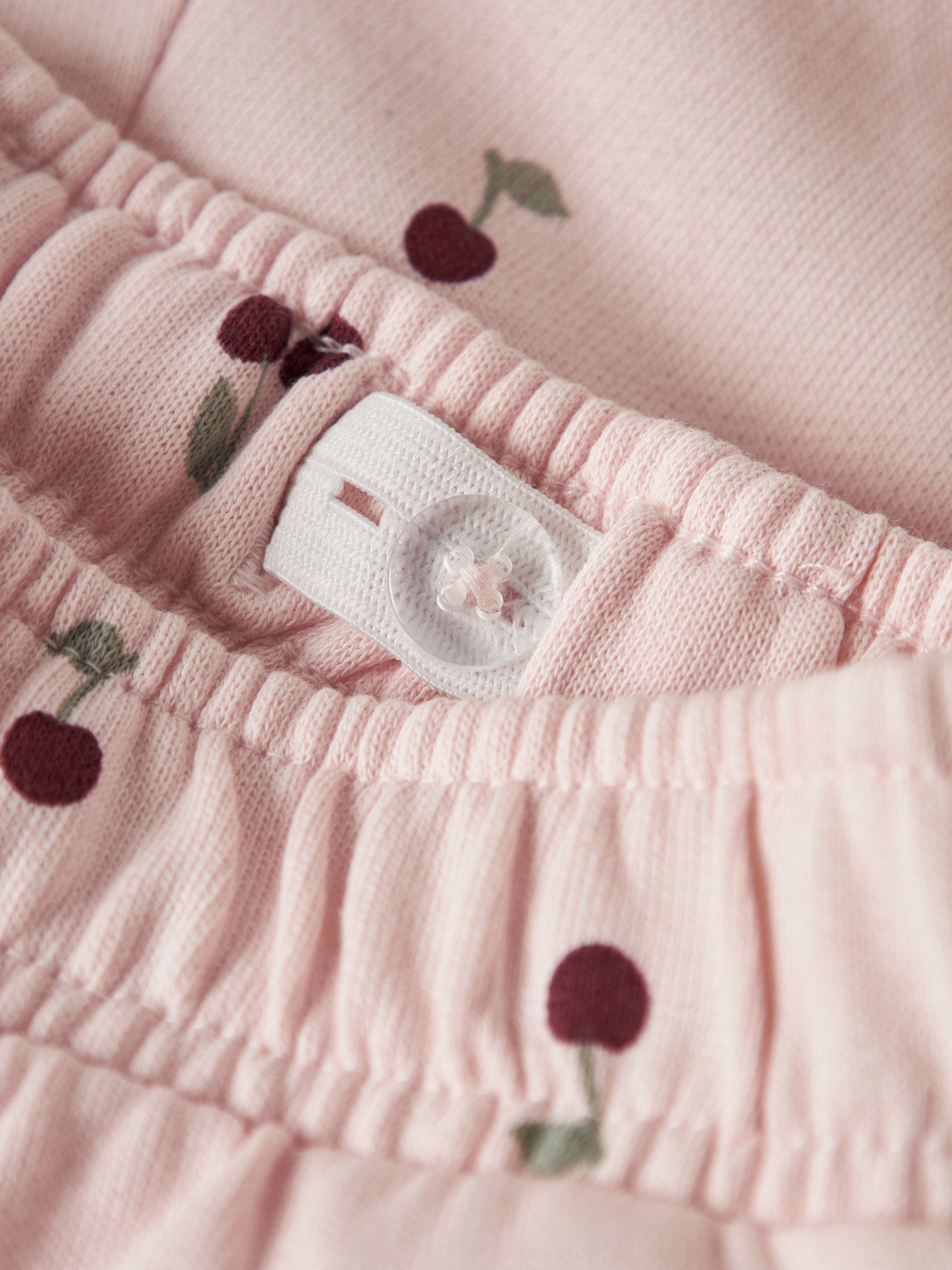 Name It ljusrosa mjukisbyxor med röda körsbär för flicka i ekologisk bomull med elastisk midja och mjuk sweatkvalitet