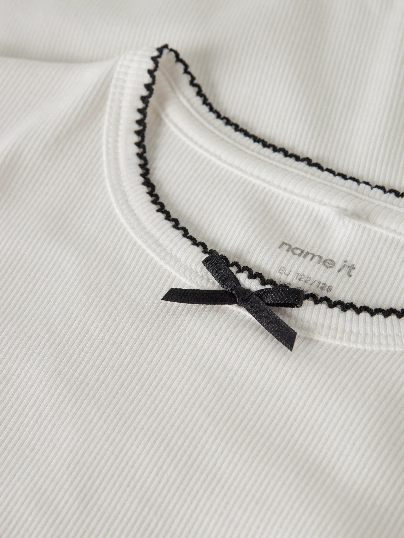 Söt vit kortärmad topp med svart rosett. T-shirt till flicka i ekologisk bomull från Name it.
NKFFIONA SS SLIM TOP PB
13251233