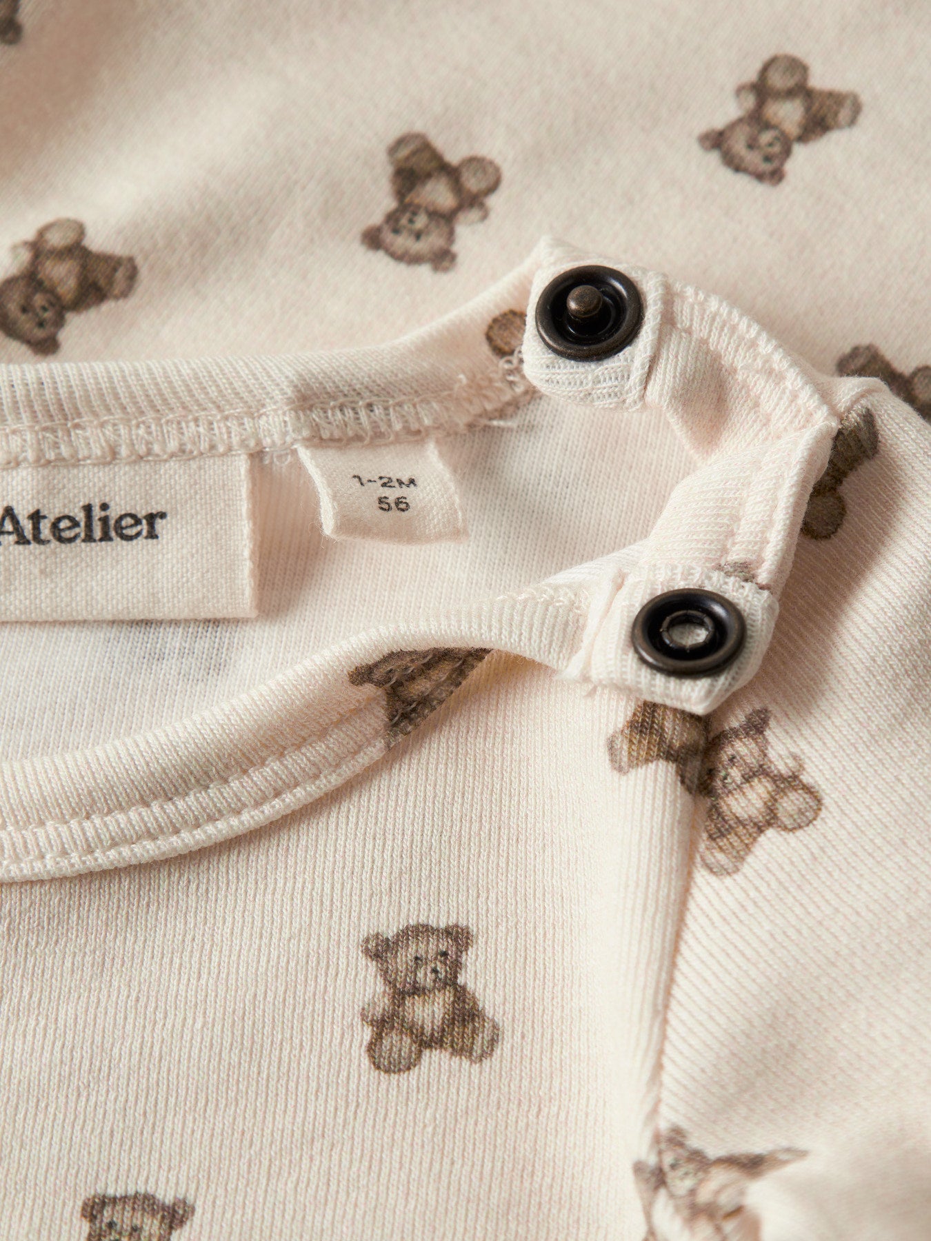 Lil' Atelier beige body med nallemönster för baby unisex i ekologisk bomull och TENCEL™ Lyocell med tryckknappar och mjuk stretchkvalitet