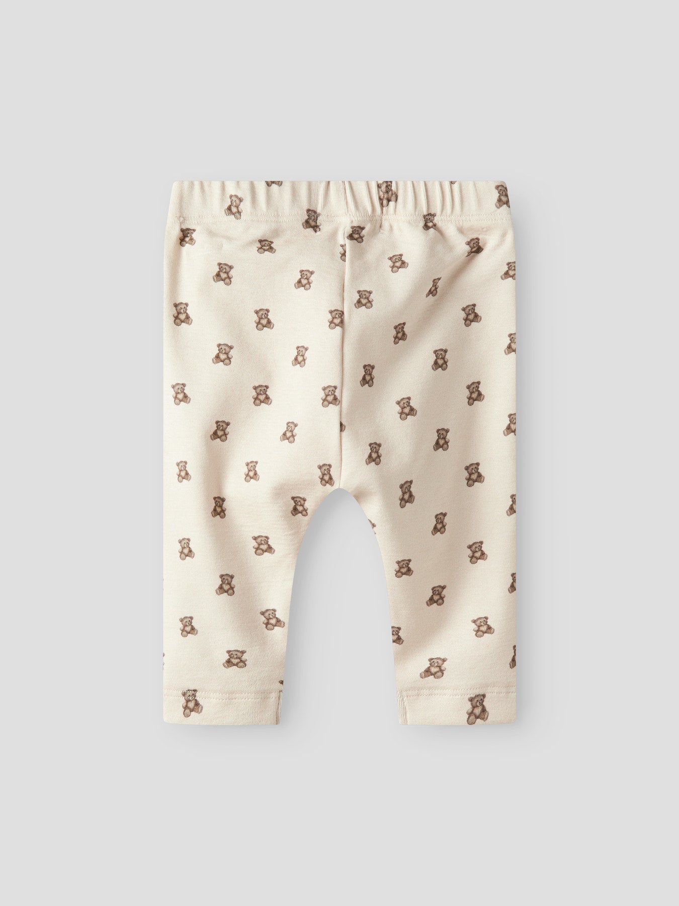 Lil' Atelier beige babybyxa till pojke och flicka med nallemönster, reglerbar midja och mjuk jerseykvalitet