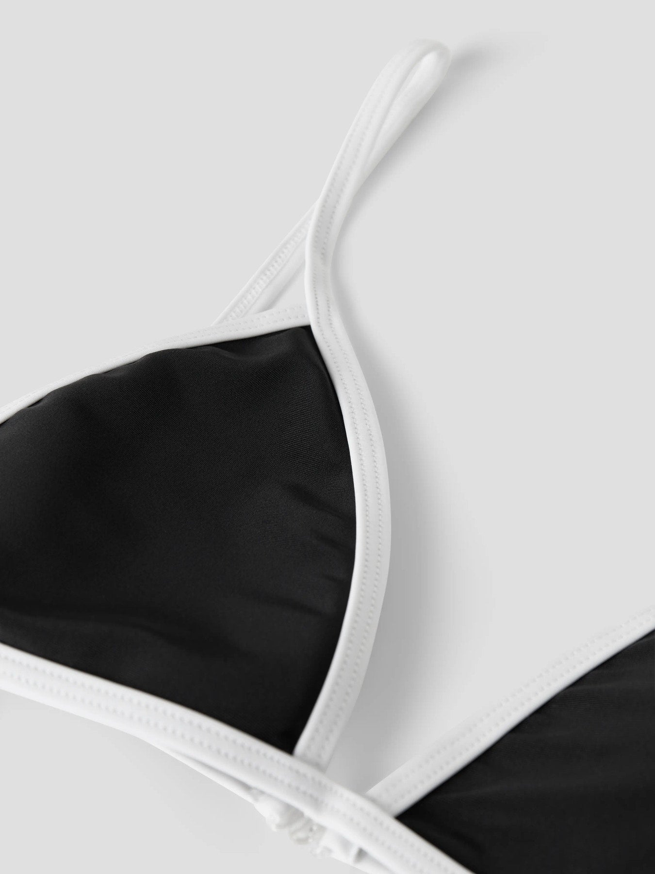 Snygg svart trekants bikini med vita kanter till tjej. Ungdoms badkläder, bikini till flicka. Sommarens snyggaste bikini topp och bikinitrosa.
NLFZINNIO BIKINI
13253796