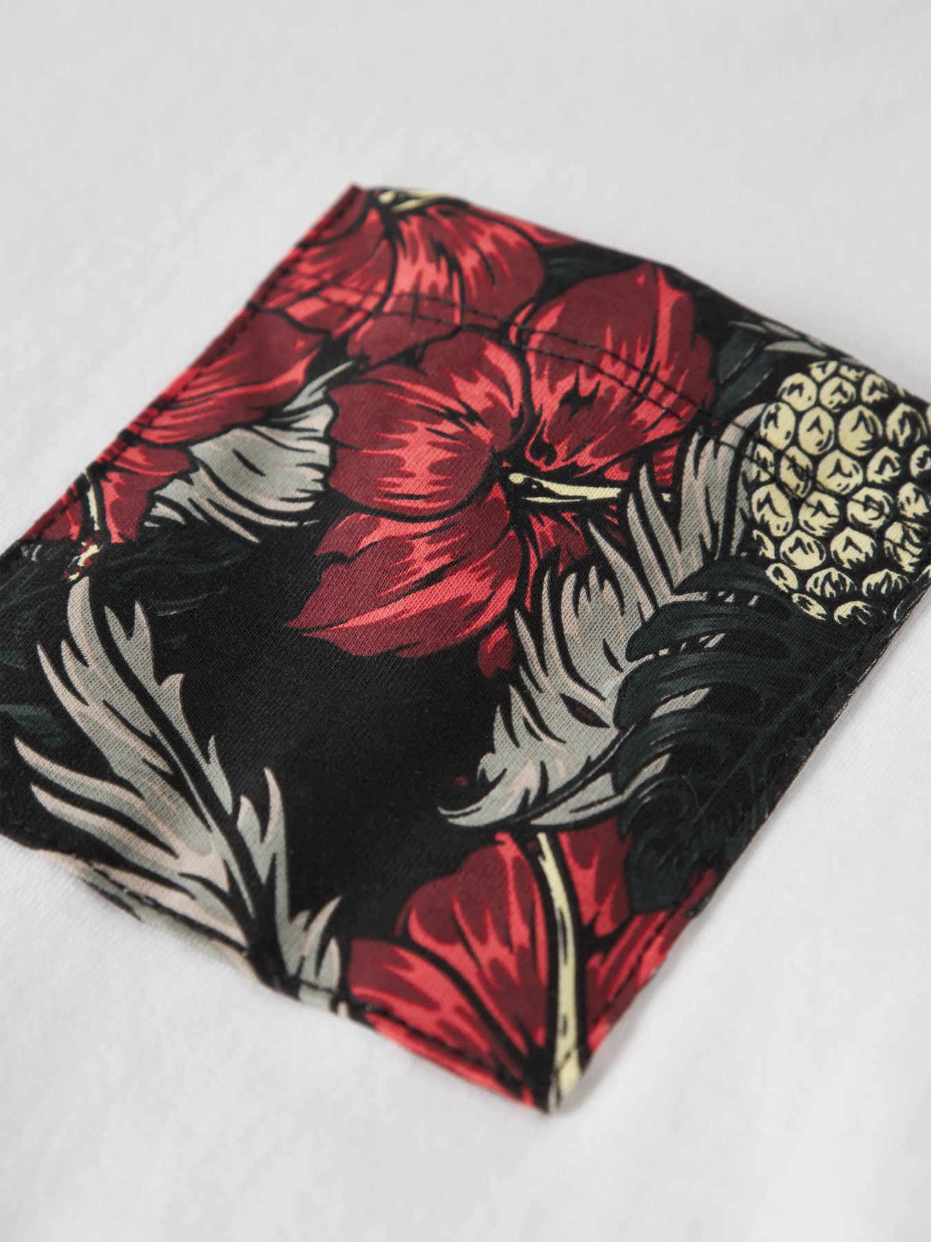 Vit t-shirt med blommig ficka till pojke. Snygg vit tröja med mönstrad bröstficka i blommigt röd och svart hawaii mönster i ekologisk bomull från Name it.
NKMFERN SS NREG TOP BOX