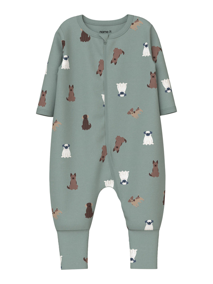 Name It grön pyjamas med hundmönster för baby och småbarn, med dragkedja och uppvikbara fötter som kan användas både med och utan fot. Modell NBMNIGHTSUIT ZIP FF DOG NOOS.