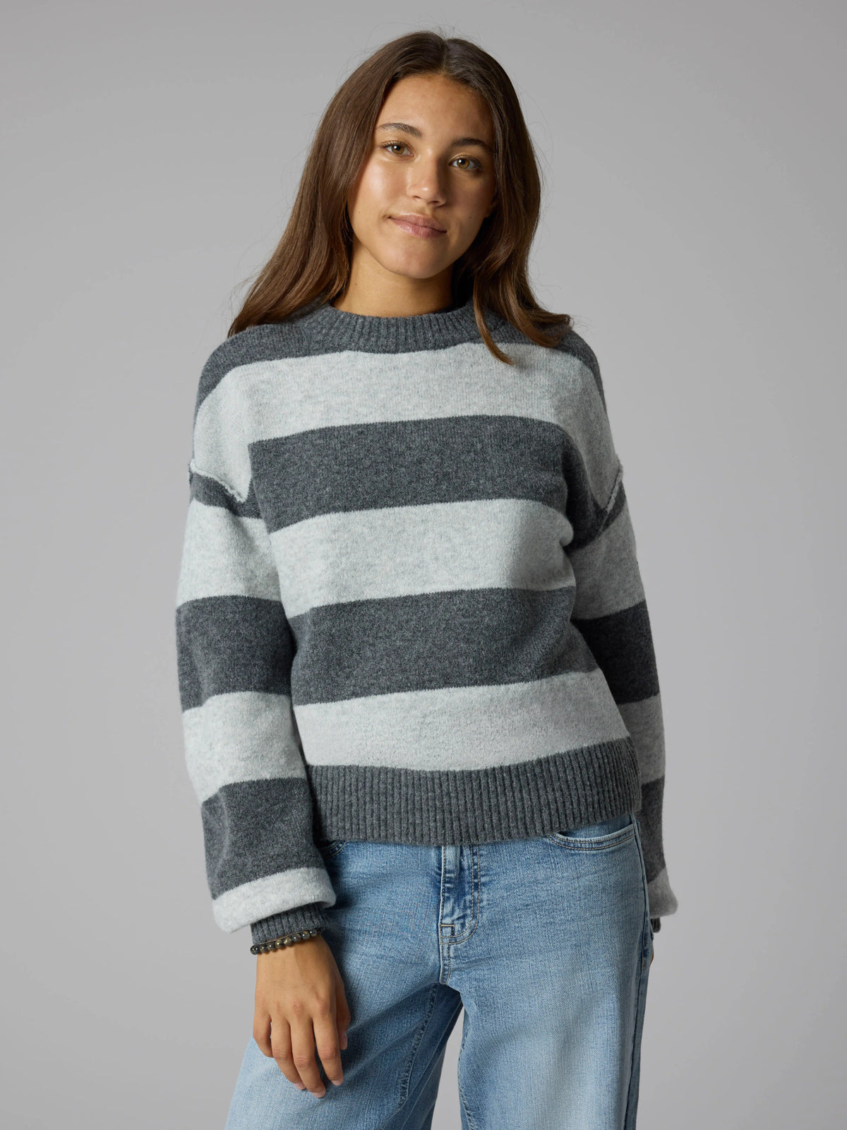 LMTD Bynthe randig stickad tröja för ungdomstjej i mörkgrå nyanser med lång ärm och mjuk fluffig kvalitet. Modell NLFBYNTHE STRIPE LS SHORT KNIT NOOS.