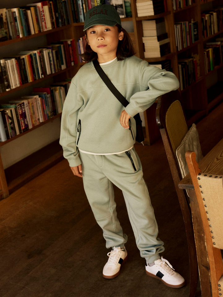 Name It Leo sweatpants för pojke med dragkedjefickor i den gröna färgen Green Milieu