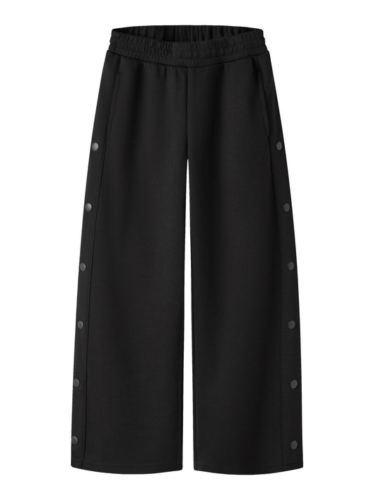 Svarta wide leg sweatpants till flicka från name it med dekorativa tryckknappar längs sidorna, sidofickor och justerbar midja.