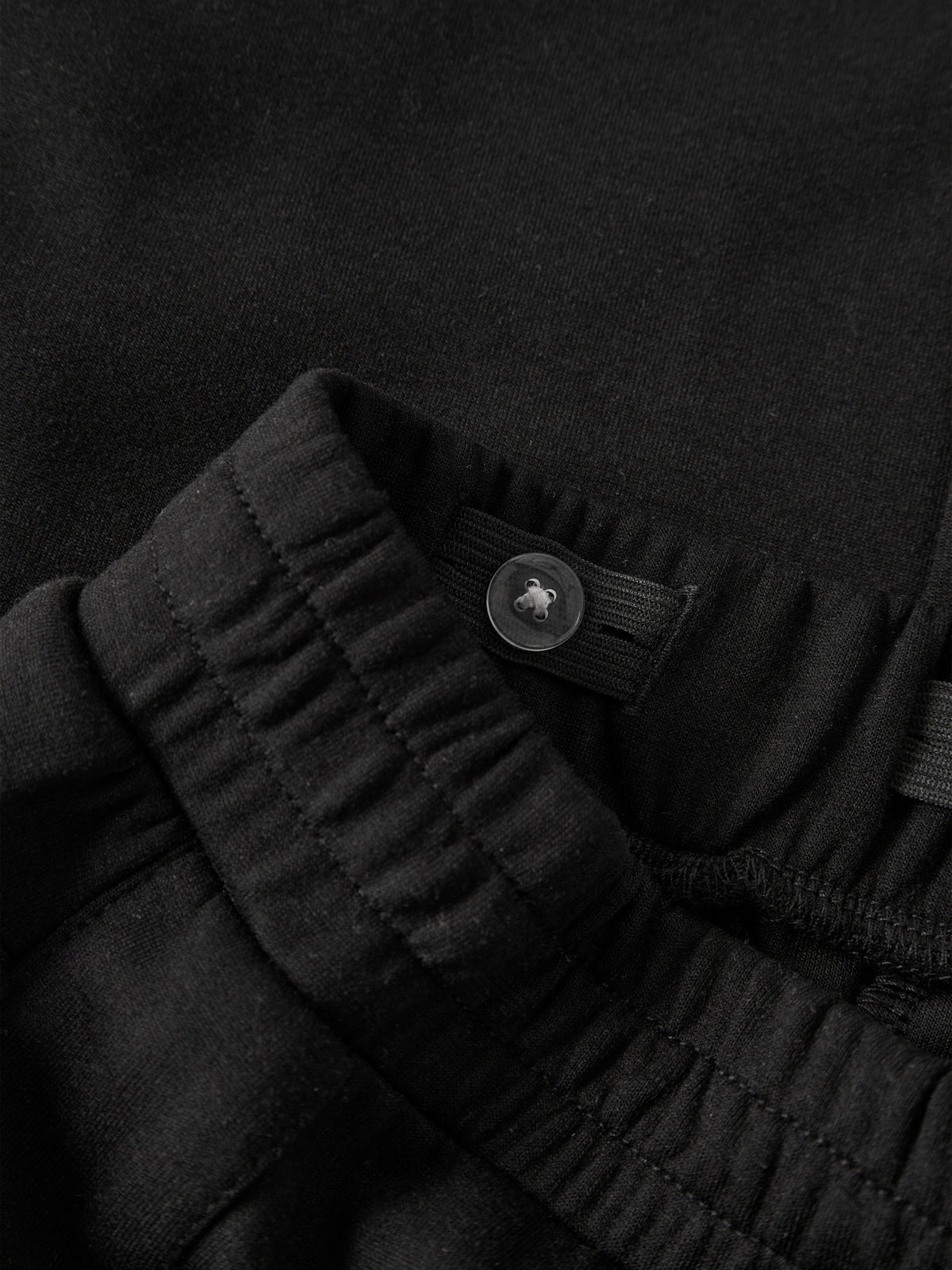 Svarta wide leg sweatpants till flicka från name it med dekorativa tryckknappar längs sidorna, sidofickor och justerbar midja.