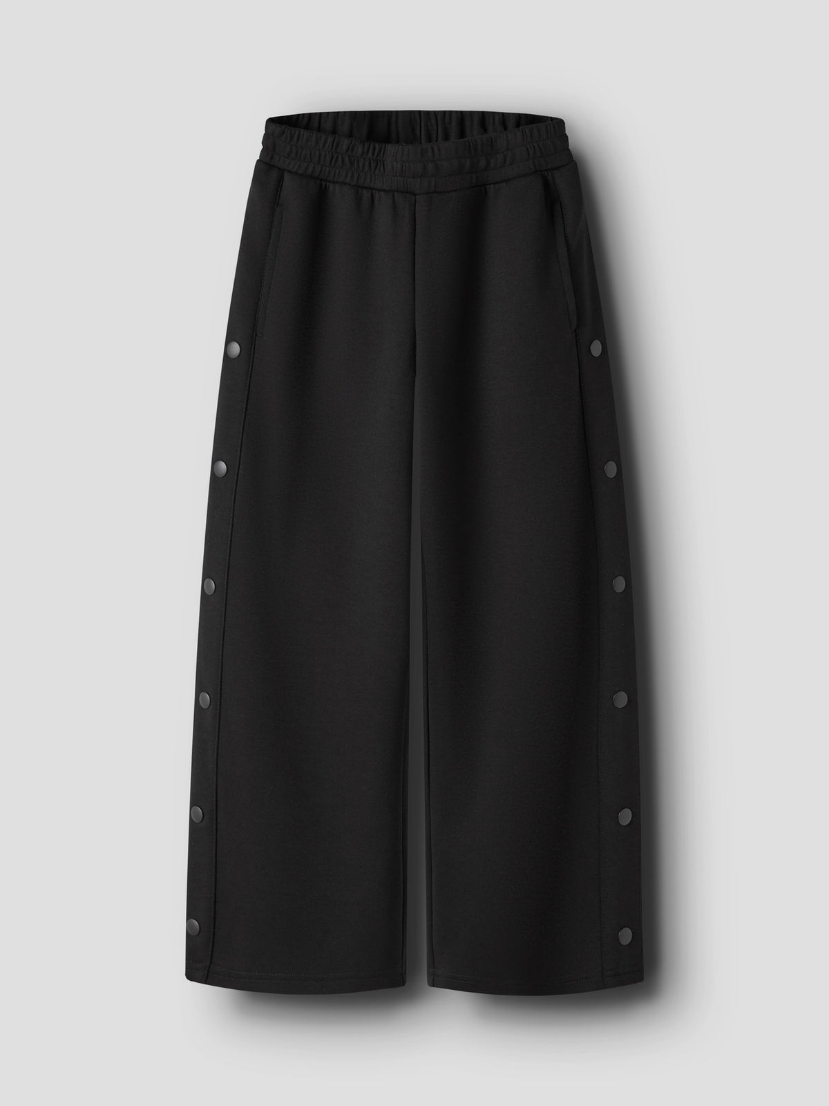 Svarta wide leg sweatpants till flicka från name it med dekorativa tryckknappar längs sidorna, sidofickor och justerbar midja.