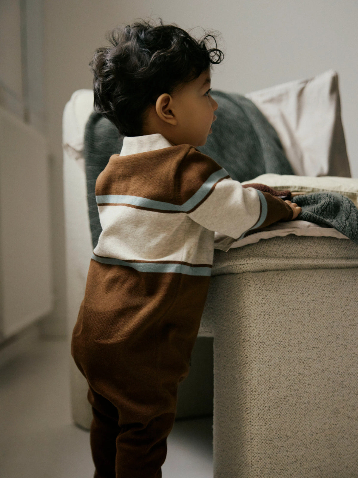 Ral brunrandig stickad babyoverall från Name It med beige pikékrage och knappar framtill.