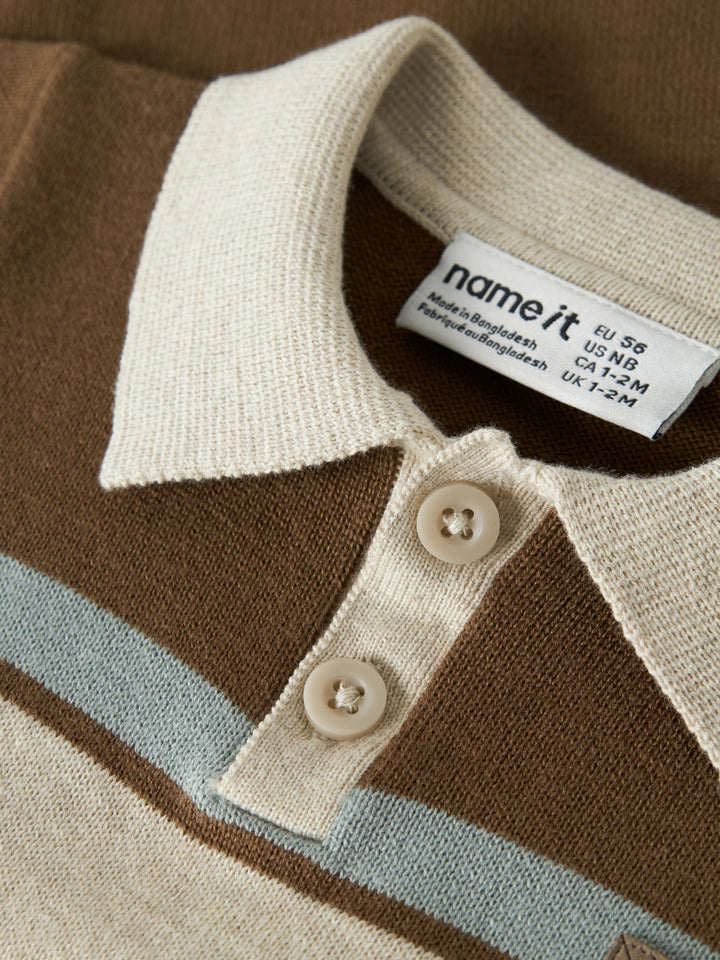 Ral brunrandig stickad babyoverall från Name It med beige pikékrage och knappar framtill.