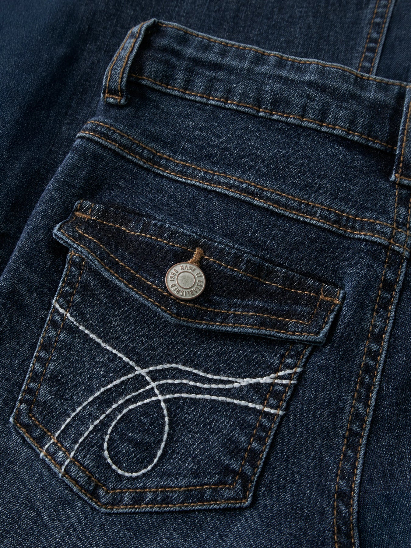 Mörkblå bootcut jeans med broderade bakfickor med lock och låg midja för flicka från Name It.