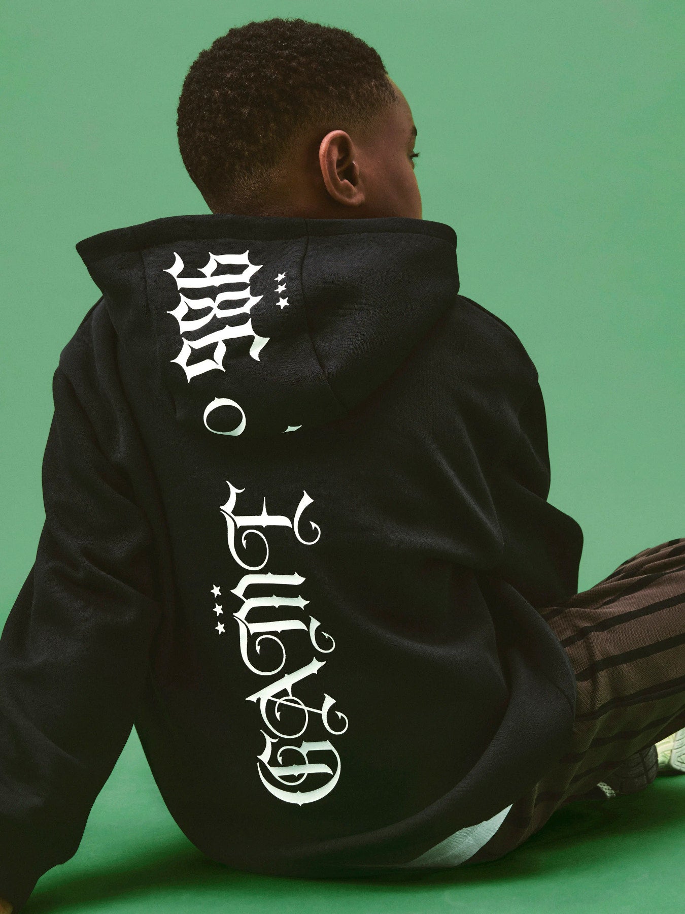 Svart Name It hoodie för pojke med texttryck fram och på ryggen.