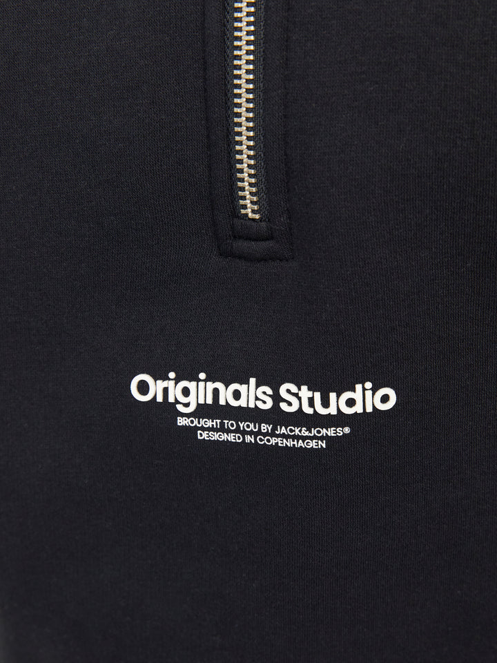 Närbild på logga origials studio. Snygg svart zip tröja till ungdom kille från Jack & Jones. Sweatshirt med hög hals och dragkedja till pojke teen. Vestrebro.