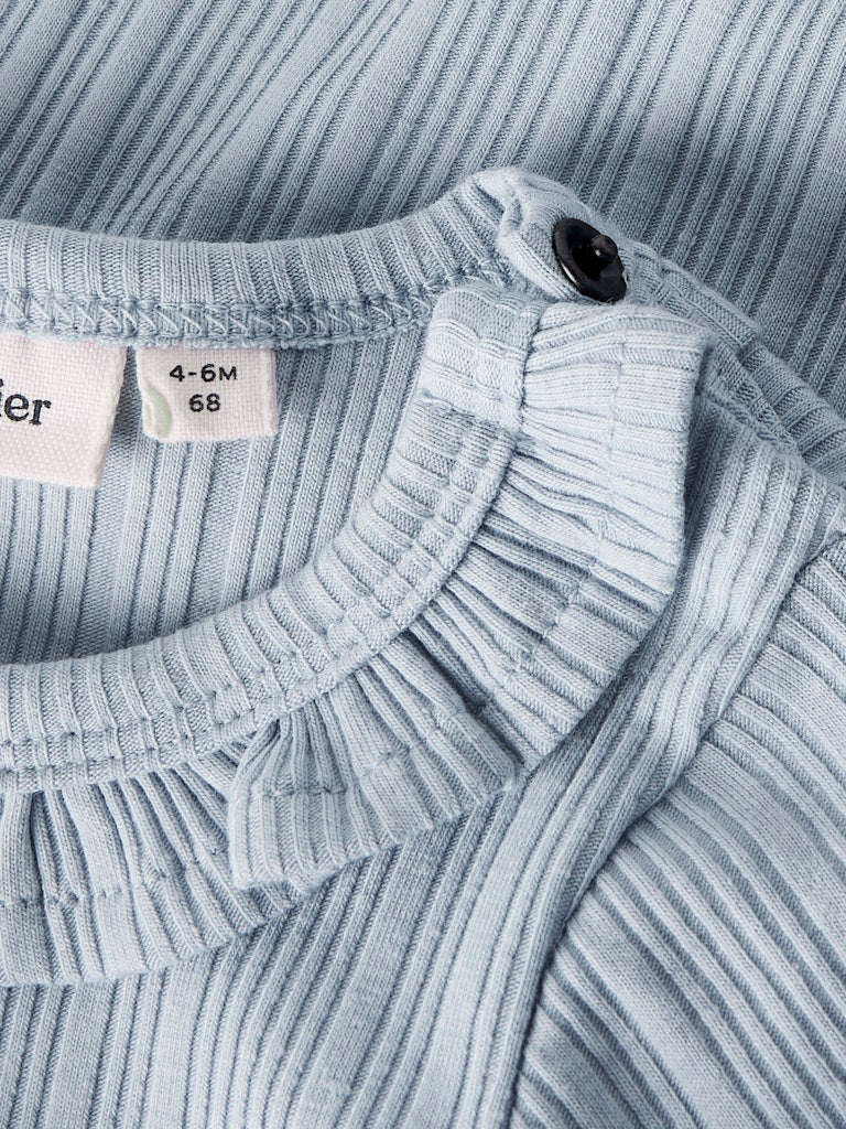 Blå baby body till flicka. Söt body suit med volanger till nyfödd bebis flicka. Ekologiska bebis kläder från Lil 'Atelier.
NBFTANSY LS SLIM BODY LIL
13250987