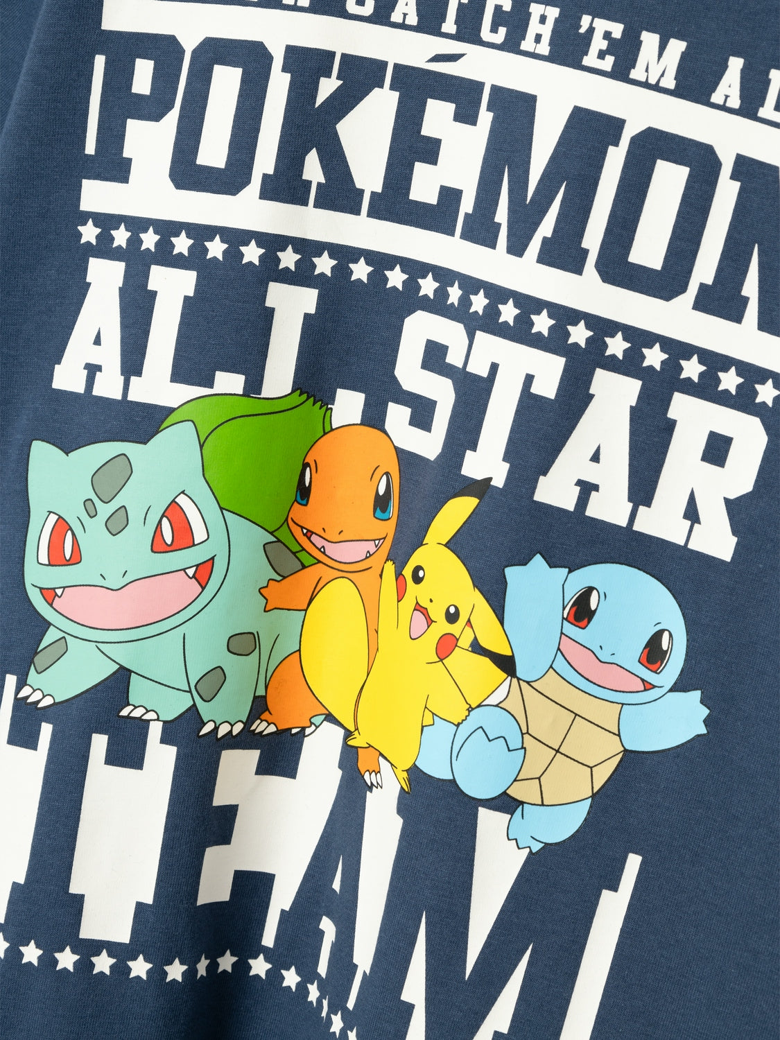 Närbild av en Kortärmad t-shirt med Pokemon tryck på bröstet. Alla pokemonfigurer syns på denna tröja.