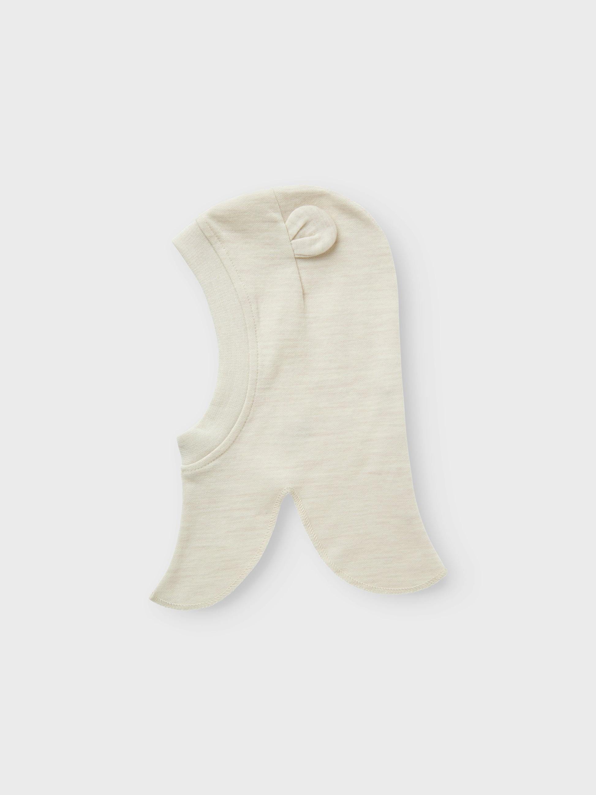 Söt beige balaclava till din baby pojke eller flicka. Mysig mössa som sitter bra på din bebis huvud och du vet att det inte blir kallt i nacke, hals och att endast babyns lilla ansikte sticker fram ur den varma mössan. Ull är ett naturmaterial känt för sina termiska egenskaper, mjukhet och fluffiga utseende. I kallt väder håller ull värmen och under varma dagar absorberar den svett, vilket gör den till ett bra val oavsett årstid. 