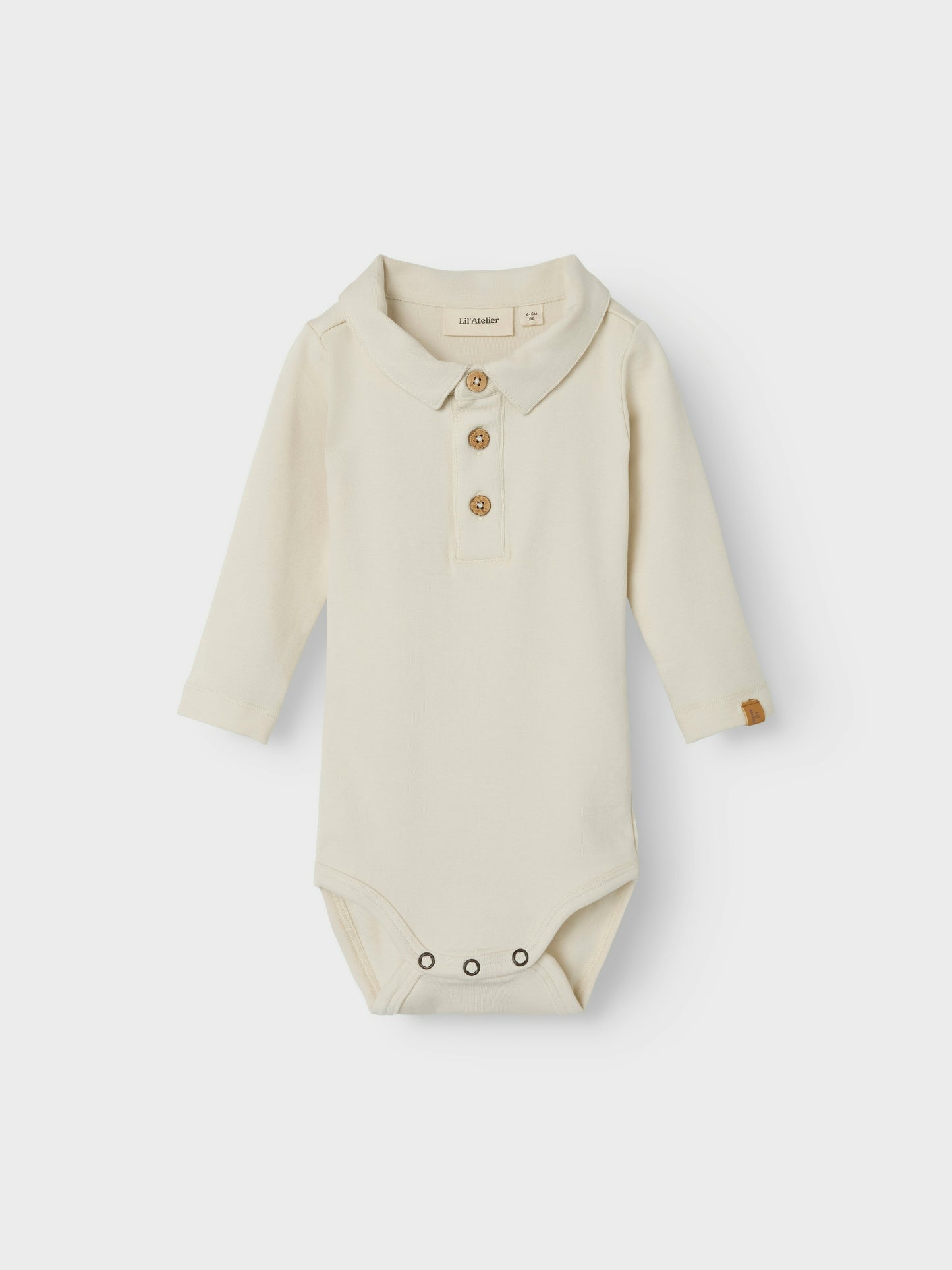 Mjuk och härlig vit baby body till pojke med piké krage. Älskad body  från Lil'Atelier som du gärna klär på din bebis istället för skjorta när ni vill vara extra fin.

Produkttyp: Polobody
Hals: Skjortkrage
Ärm: Lång ärm
Stängning: Knäppning med knapp, tryckknapp
Extra detaljer: Etikett

Sätt ihop den perfekta outfiten för ditt barn med kvalitativa vardagsstilar och skapa en bekväm och trendig look. Jersey är ett lätt och stretchigt tyg med en mjuk yta och insida för en bekväm känsla och rörelsefrihet.