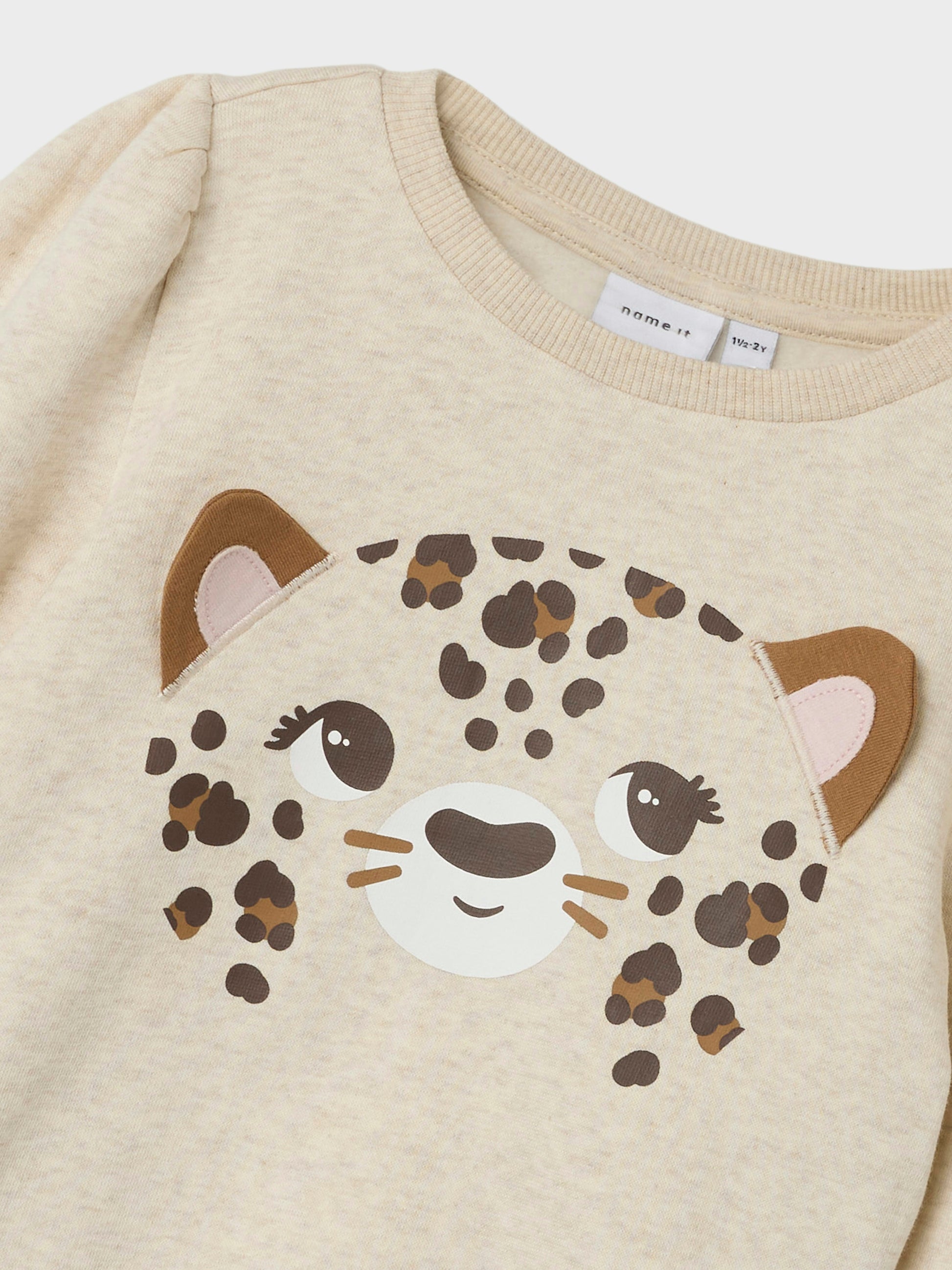 Beige sweatshirt tröja med söt leopard på bröstet. Långärmad topp i ekologisk bomull som är mjuk och skön och passar utmärkt när din flicka, tjej leker.

Produkttyp: Sweatshirts
Hals: Rund hals
Ärm: Långa ärmar
Ärmar: Puffärmar
Muddar: Ribbstickade muddar
Extra detaljer: Ribbkant
Tryck : Pigmenttryck för ett mjukt tryck på lättare tyger
Passform: Normal passform
Fästkomp: Bomull

Skapa en trendig och avslappnad look. Borstad sweat