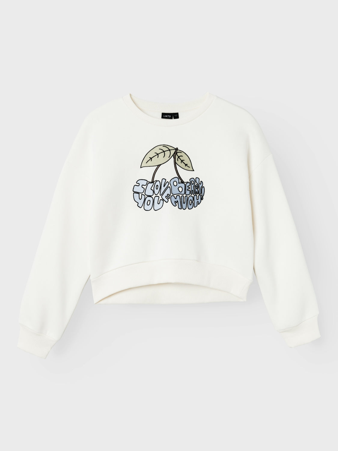 Vit sweatshirt i kort modell. Långärmad tröja med print på bröstet av körsbär som egentligen inte är bär utan text som är formad till bär.