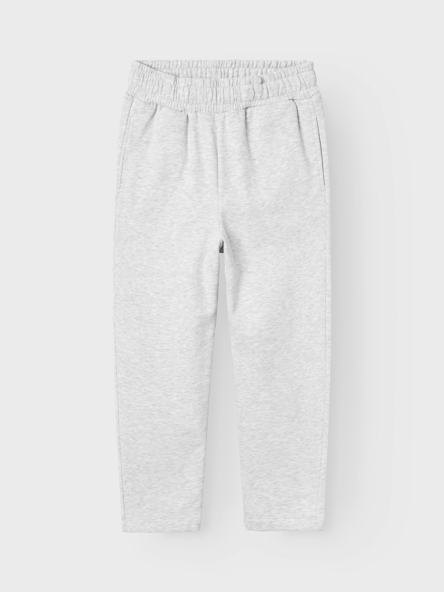 Ekologisk grå jogging byxa till tjej, barn och tonåring. Snygg enkel byxa med rakt benslut, precis rätt modell enligt trenden. Sätt ihop den perfekta outfiten för ditt barn med kvalitativa vardagsstilar och skapa en bekväm och trendig look. Borstad sweatshirt har en mjuk insida för en bekväm känsla.