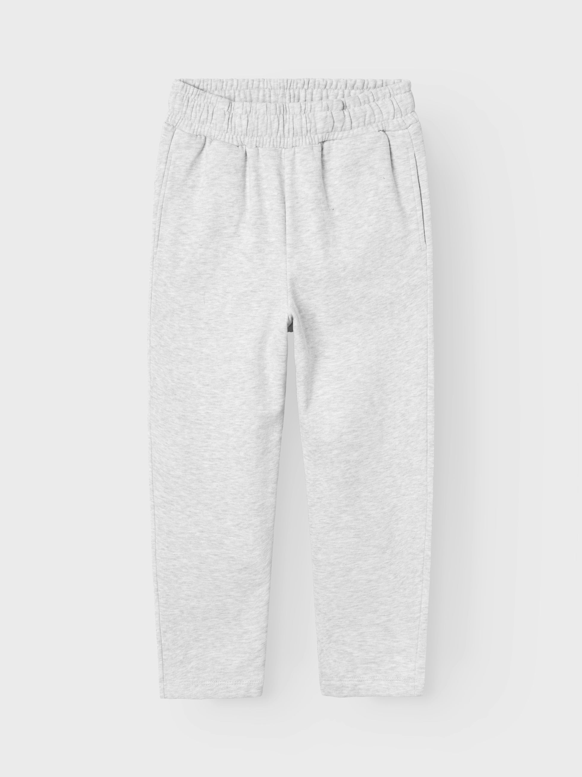 Ekologisk grå jogging byxa till tjej, barn och tonåring. Snygg enkel byxa med rakt benslut, precis rätt modell enligt trenden. Sätt ihop den perfekta outfiten för ditt barn med kvalitativa vardagsstilar och skapa en bekväm och trendig look. Borstad sweatshirt har en mjuk insida för en bekväm känsla.