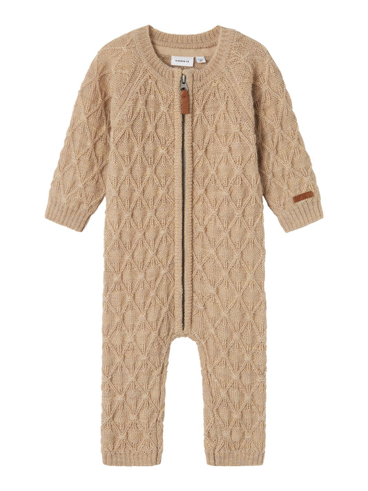 Beige baby overall i mjukaste stickad ull så att den bebis flicka och pojke alltid är rätt klädd oavsett temperatur. Ull, merinoull har den fantastiska egenskapen att den värmer när det är kallt och kyler om det är varmt vilket är extra bra på små barn.

Produkttyp: Overall
Stängning: Dragkedja
Extra detaljer: Badge