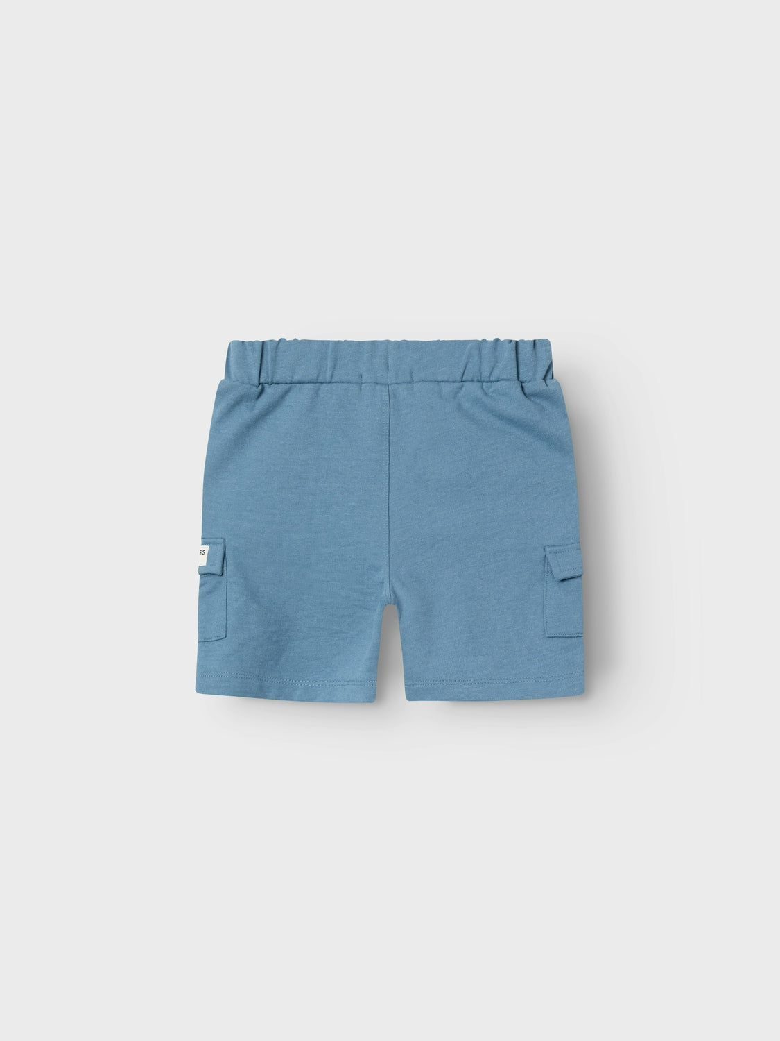 Baksidan på blå mjukis shorts med fickor på låren till pojke. Barn shorts med reglerbar midja.