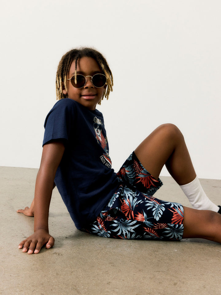 Kille klädd i blå kortärmad t-shirt till pojke. Ekologiska barn kläder från Name it. Hund, surfbräda i roligt print på cool sommar t-shirt.
NKMFULDME SS TOP BOX
13241615