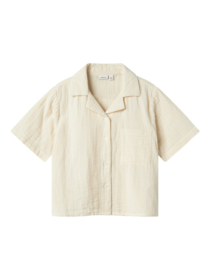 Kortämad beige blus, skjorta i sval och skön muslin till flicka, tjej. Barn topp till flicka från Name it.
NKFJASMIN SS SHORT SHIRT NOOS
13240427