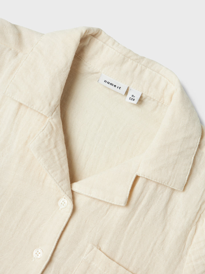 Kortämad beige blus, skjorta i sval och skön muslin till flicka, tjej. Barn topp till flicka från Name it.
NKFJASMIN SS SHORT SHIRT NOOS
13240427