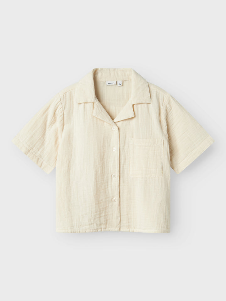 Kortämad beige blus, skjorta i sval och skön muslin till flicka, tjej. Barn topp till flicka från Name it.
NKFJASMIN SS SHORT SHIRT NOOS
13240427