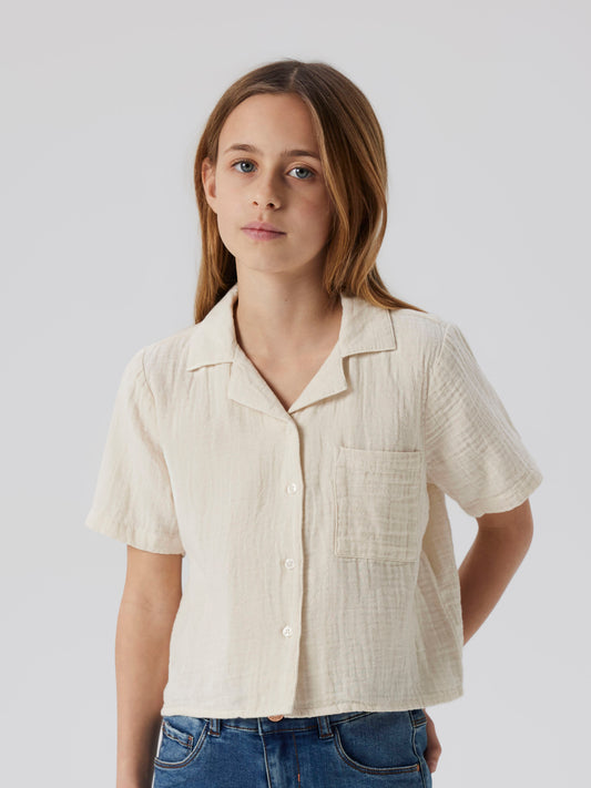 Tjej klädd i kortämad beige blus, skjorta i sval och skön muslin till. Barn topp till flicka från Name it.
NKFJASMIN SS SHORT SHIRT NOOS
13240427