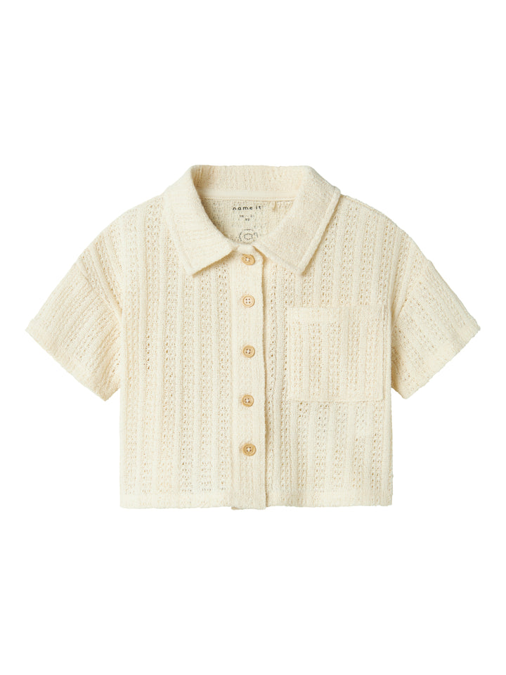 Vit, ljus beige kortärmad spets skjorta, blus till flicka i ekologisk bomull från Name it. Vacker fest, fin topp som passar både till byxor och kjol.
NMFFEEL SS SHORT SHIRT
13241211