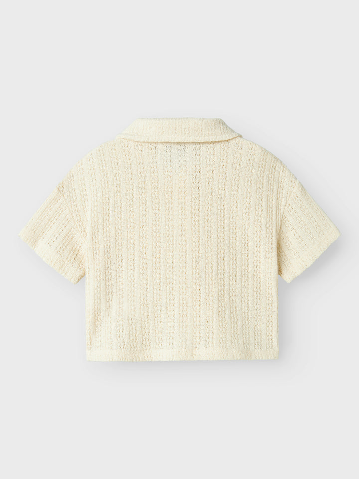 Vit, ljus beige kortärmad spets skjorta, blus till flicka i ekologisk bomull från Name it. Vacker fest, fin topp som passar både till byxor och kjol.
NMFFEEL SS SHORT SHIRT
13241211