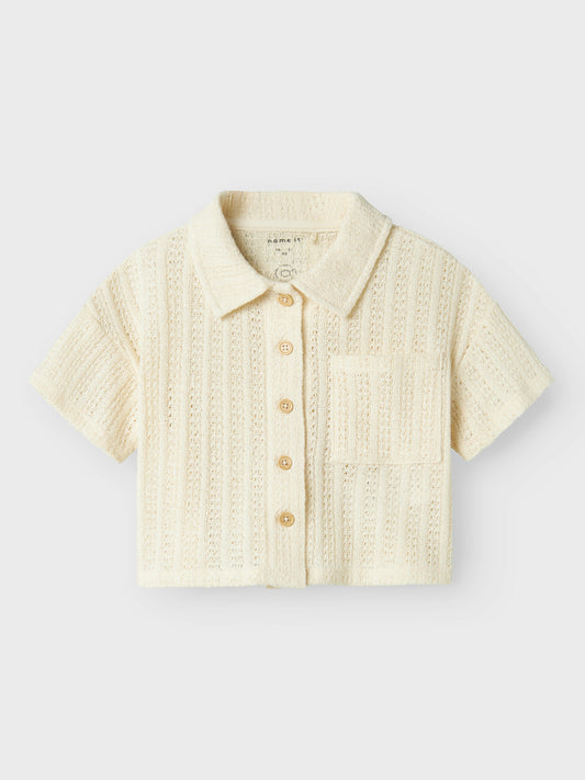 Vit, ljus beige kortärmad spets skjorta, blus till flicka i ekologisk bomull från Name it. Vacker fest, fin topp som passar både till byxor och kjol.
NMFFEEL SS SHORT SHIRT
13241211